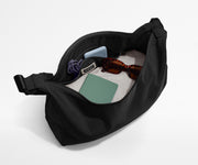 Featherlight crossbody packed with a sweater, notebook, sunglasses, and portable charger