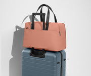 The Overnight Bag secured to an Away checked suitcase using the trolley sleeve