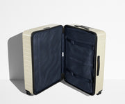 The Large suitcase in Salt White (Gloss) shown open in an upright position to show interior organization and compression system