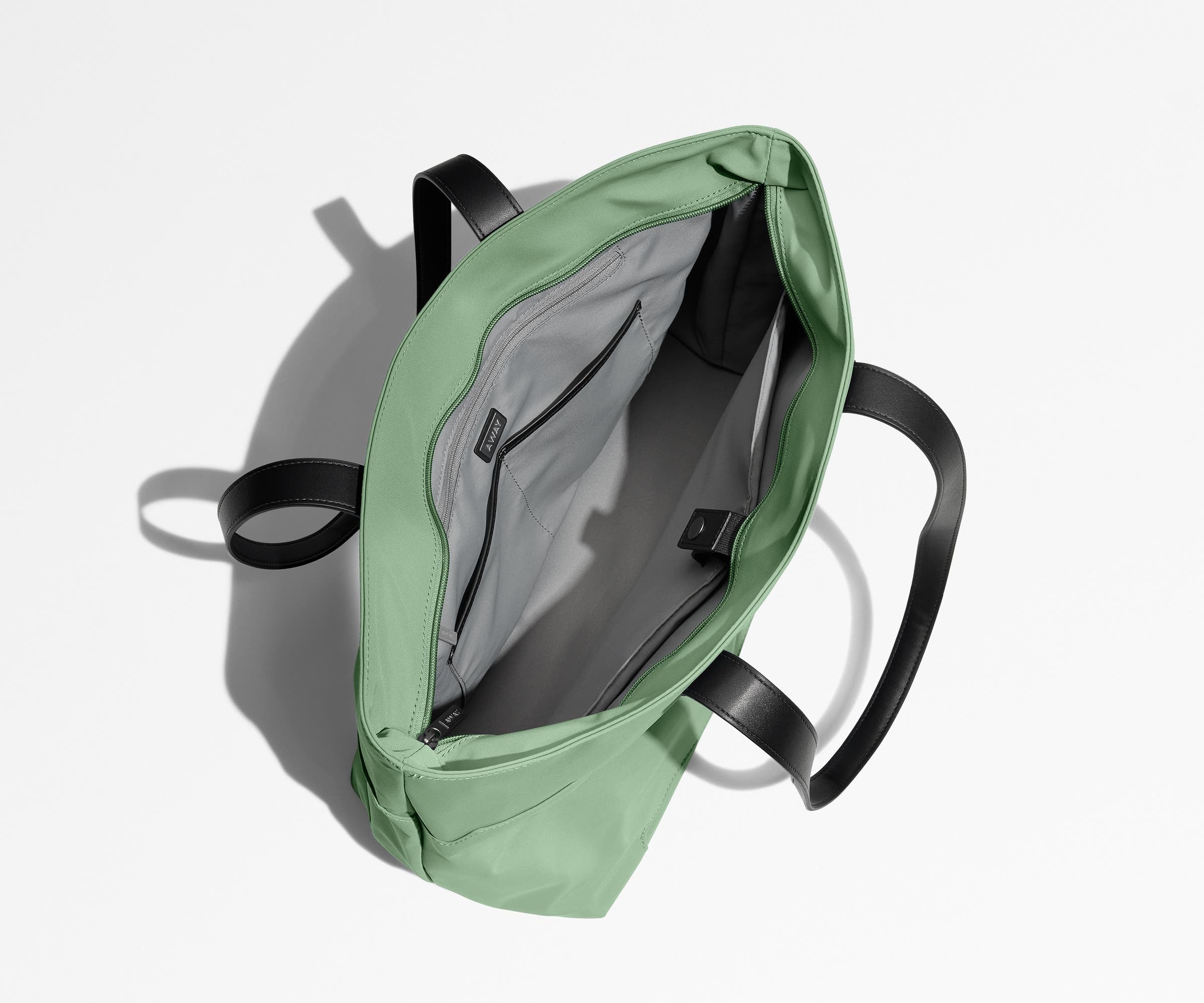 Unzipped and unpacked Everywhere Tote bag, showing the interior zip pockets, slip pockets, and laptop pocket