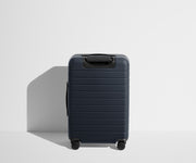 Back product view of The Bigger Carry-On suitcase in Navy Blue