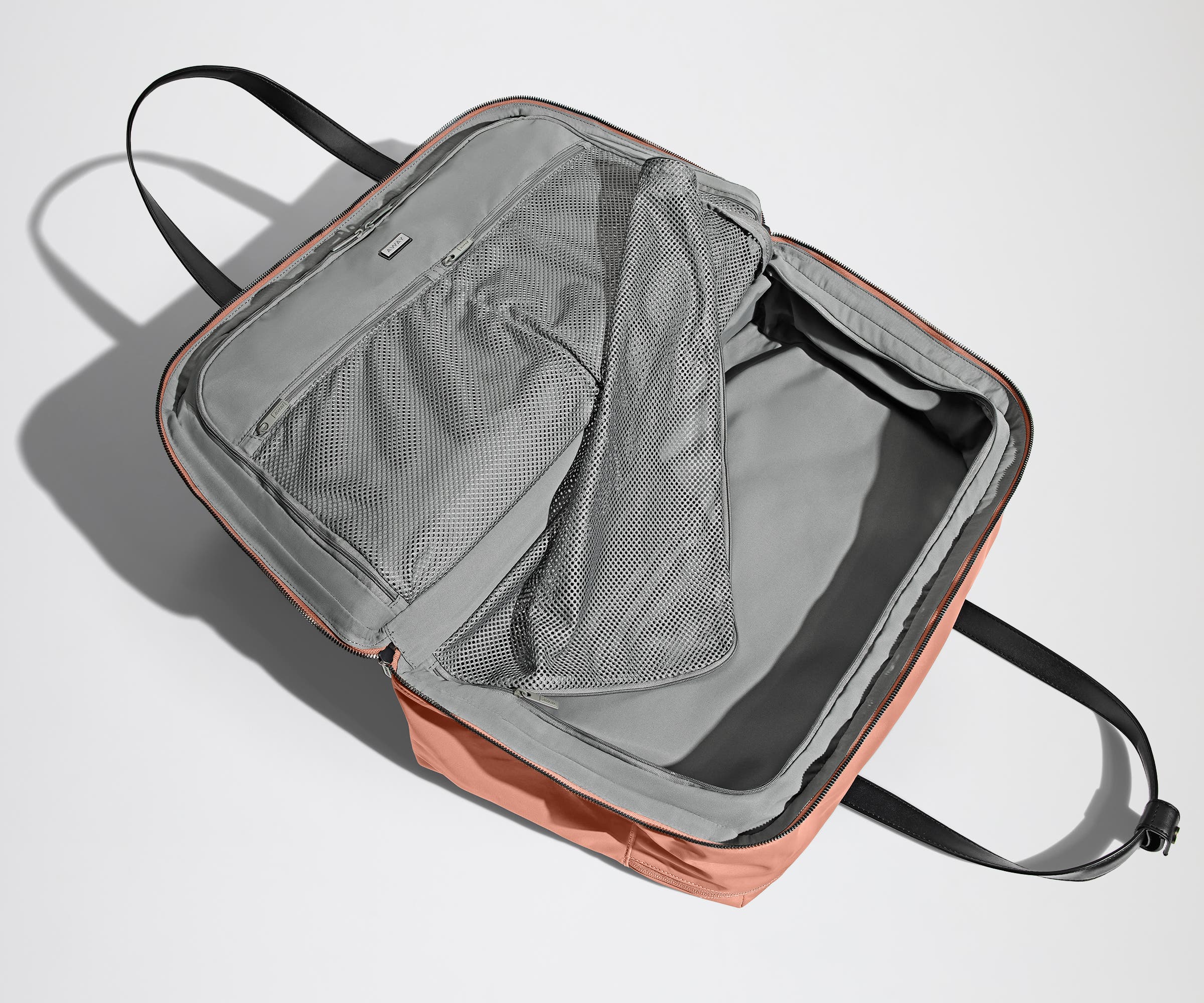 Open clamshell Weekender bag packed with travel essentials, including clothes and Small Toiletry Bag