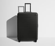 Front product view of The Large suitcase in Jet Black with raised handle