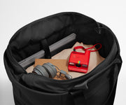 Interior packed with clothing, a laptop, headphones, notebook, and camera