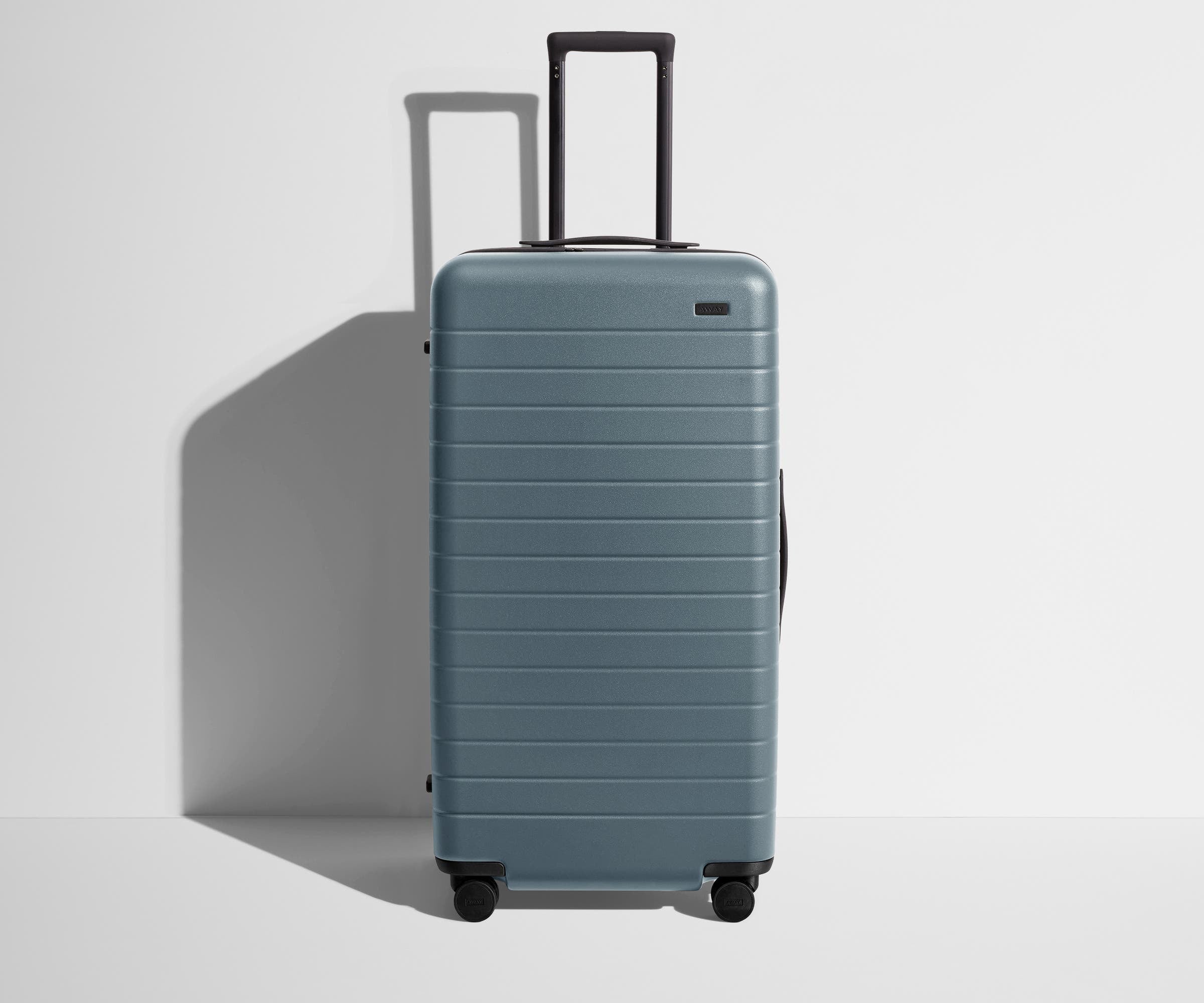 Front product view of The Trunk suitcase in Coast Blue with raised handle