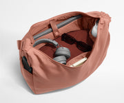 Large Featherlight Crossbody packed with clothes, a laptop, notebook, water bottle, headphones, and sunglasses