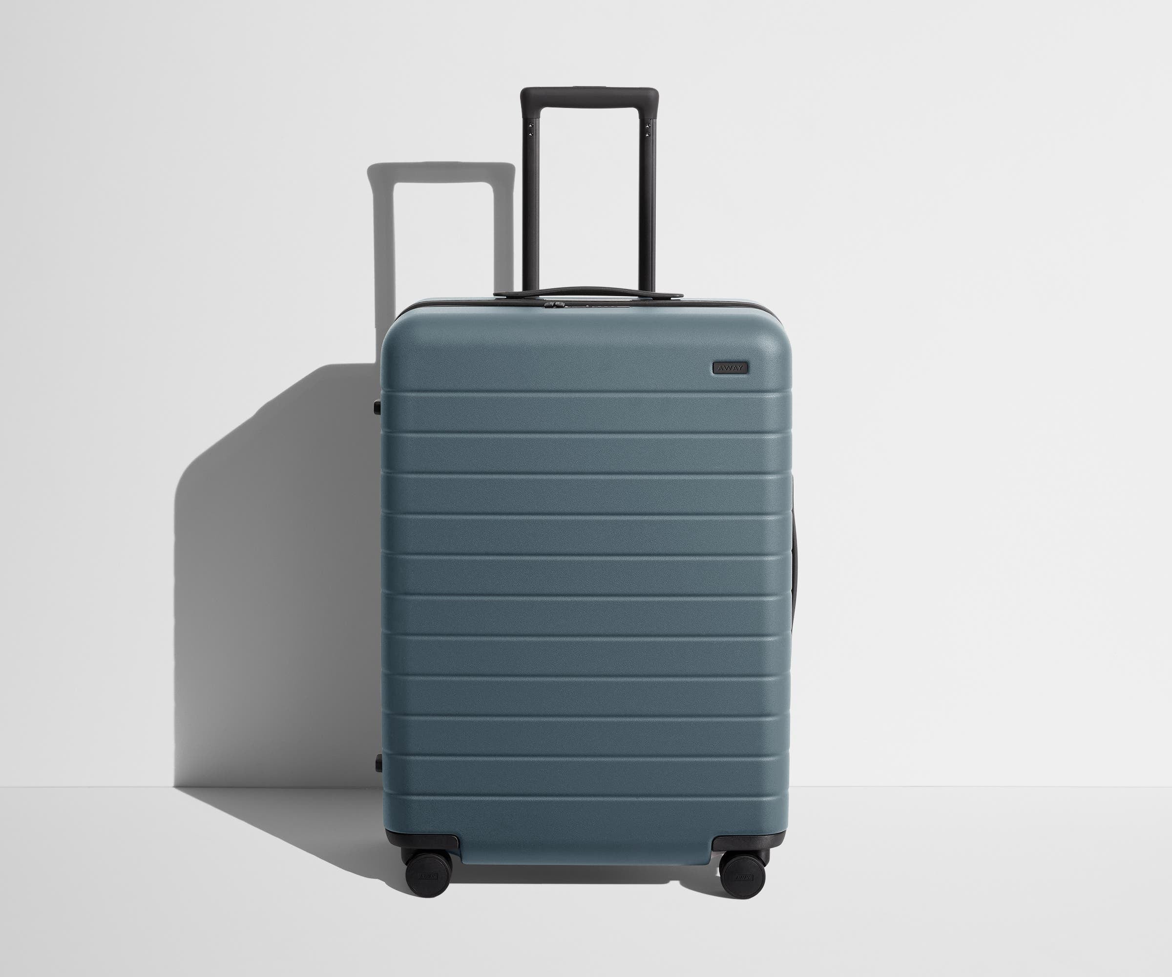 Front product view of The Medium suitcase in Coast Blue with raised handle