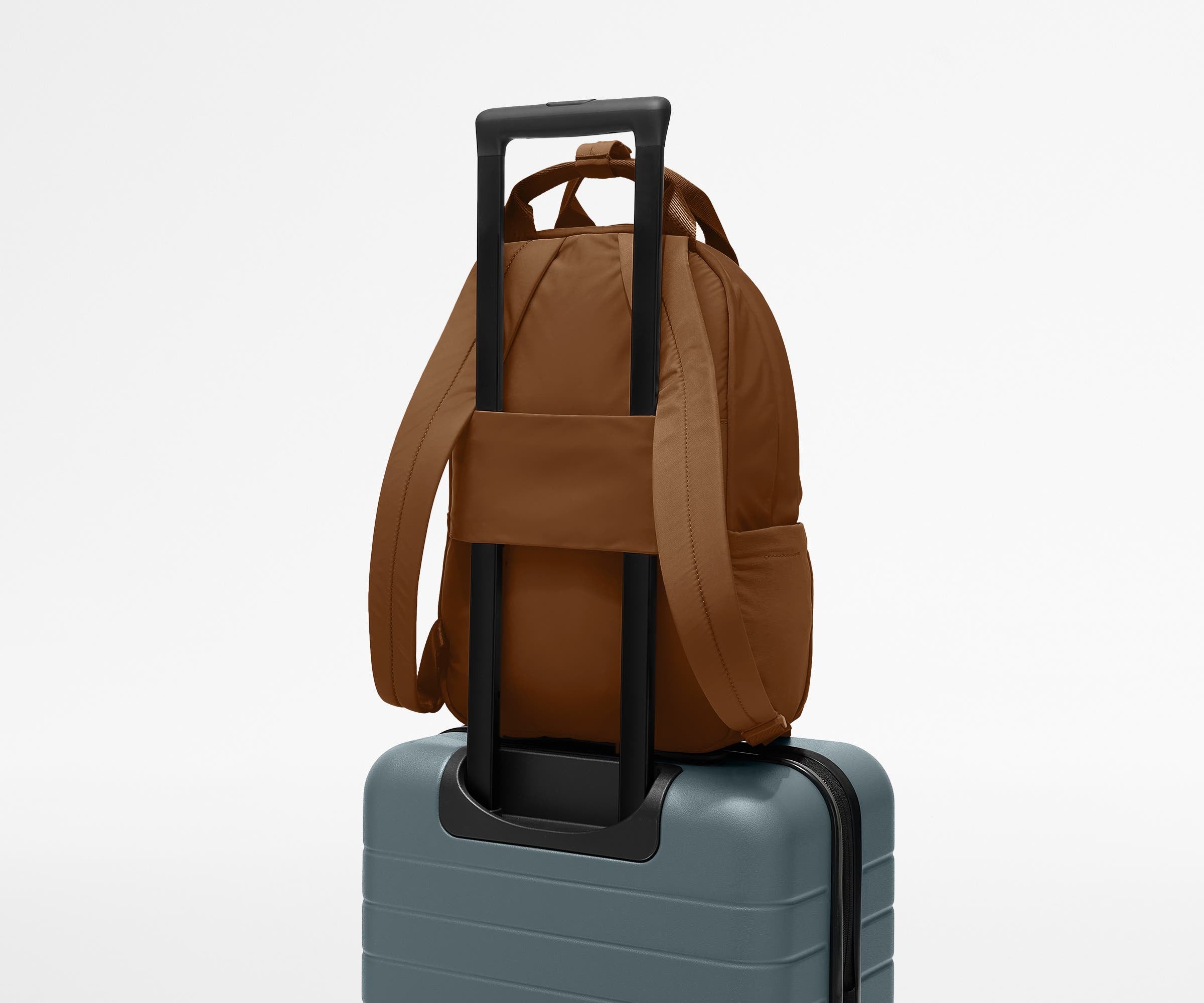 Featherlight Backpack on top of an Away suitcase, attached by the trolley sleeve