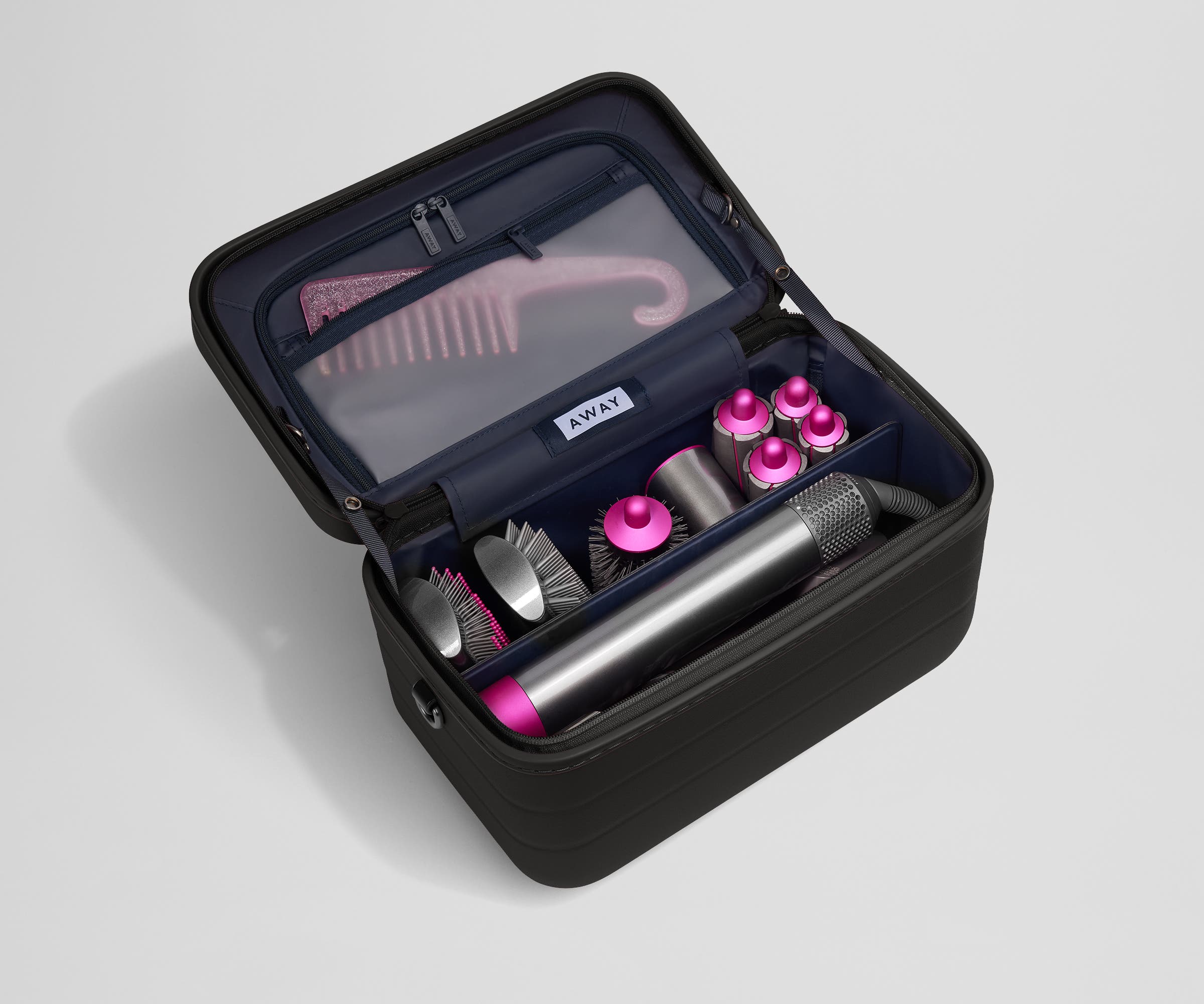 Train case packed with hair tools including a blow dryer and its attachments and a Brush