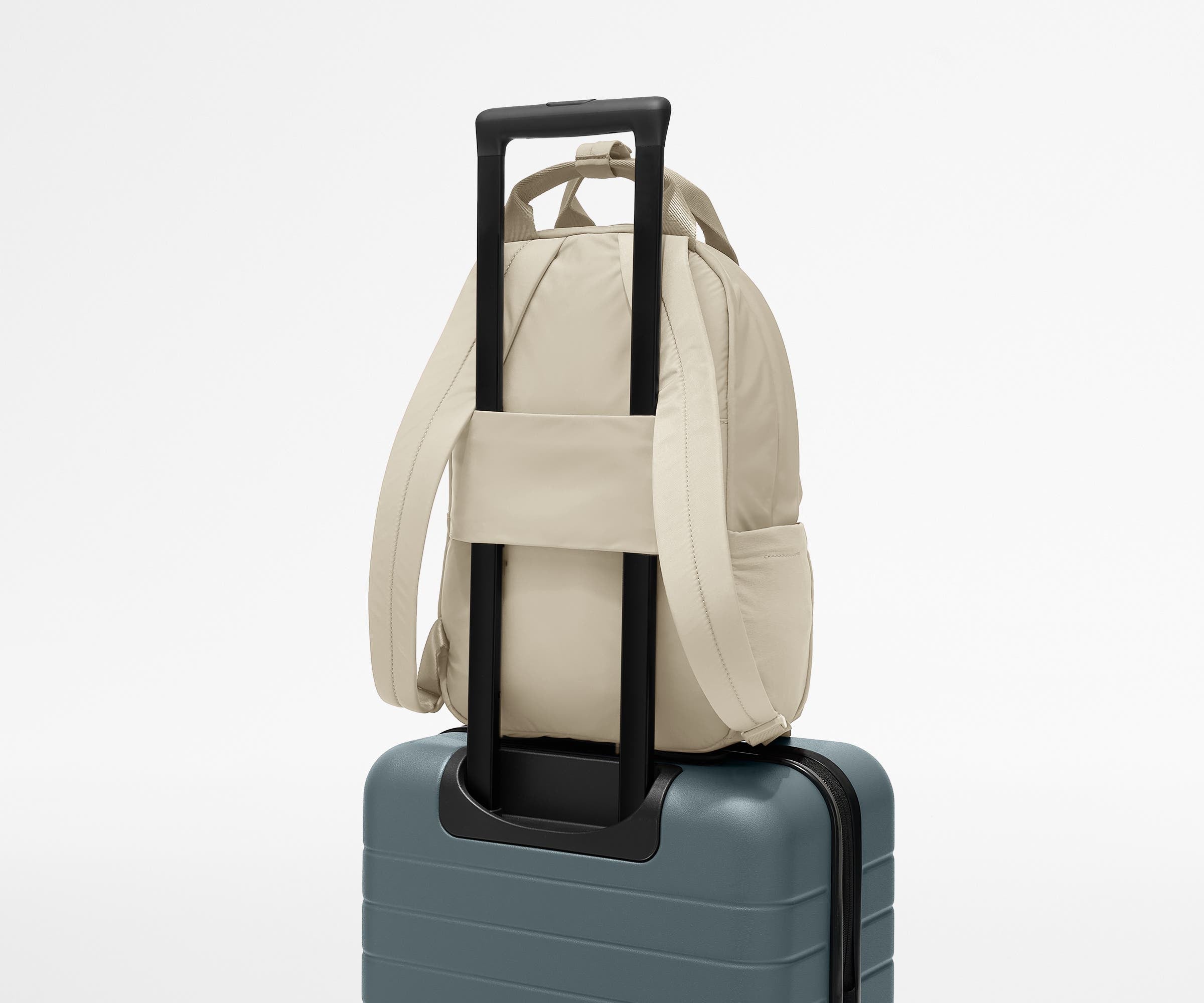 Featherlight Backpack on top of an Away suitcase, attached by the trolley sleeve