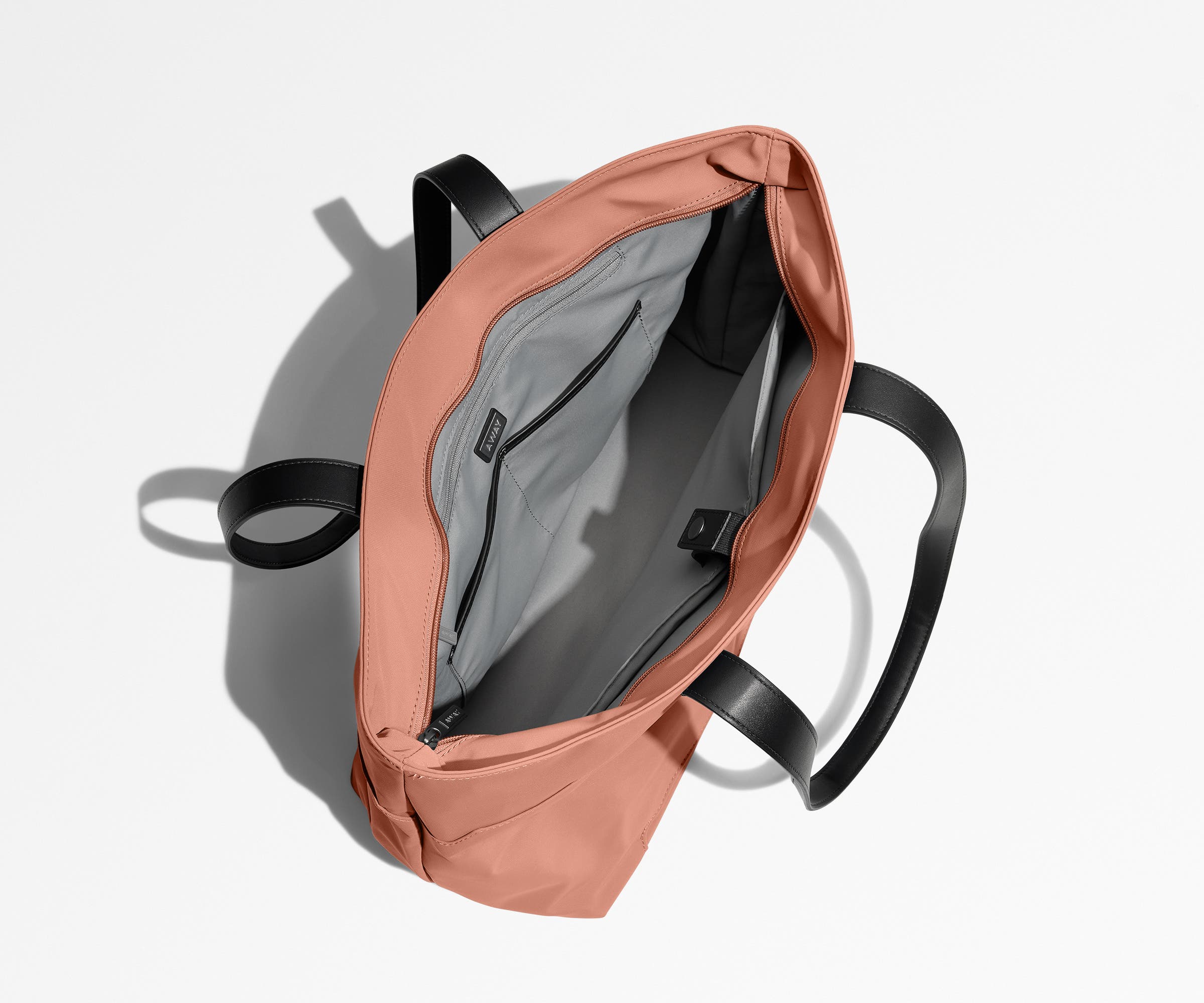 Unzipped and unpacked Everywhere Tote bag, showing the interior zip pockets, slip pockets, and laptop pocket