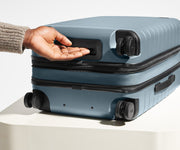 The Bigger Carry-On Flex suitcase in Coast Blue shown from below highlighting the underside grab handle