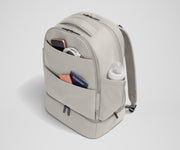 Exterior front pockets packed with travel essentials like a passport and phone, and the exterior bottle pocket packed with a milk bottle