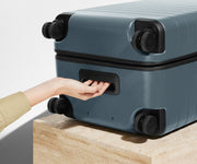 The Trunk suitcase in Coast Blue shown from below highlighting the underside grab handle