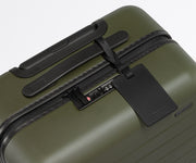 The Carry-On suitcase in Olive Green shown shown from above highlighting TSA-approved combination lock and recycled leather luggage tag