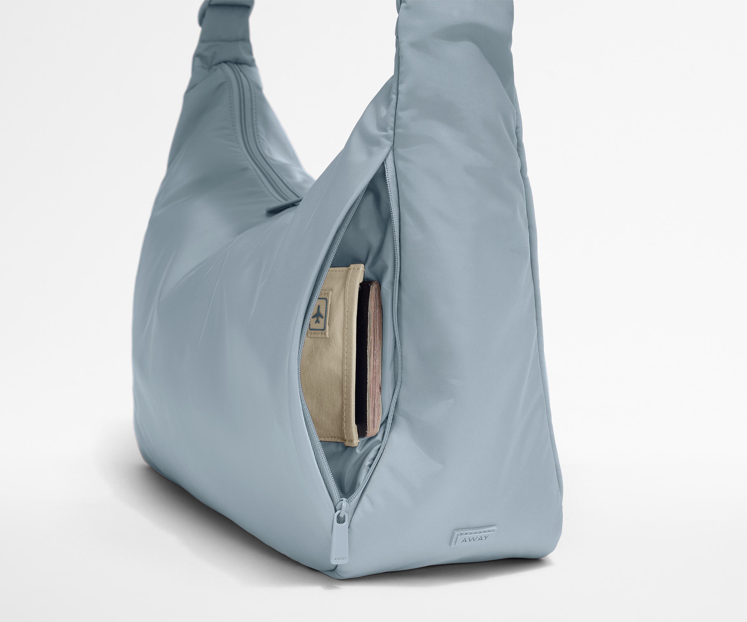 Passport shown in the travel-ready pocket in the front zippered pocket