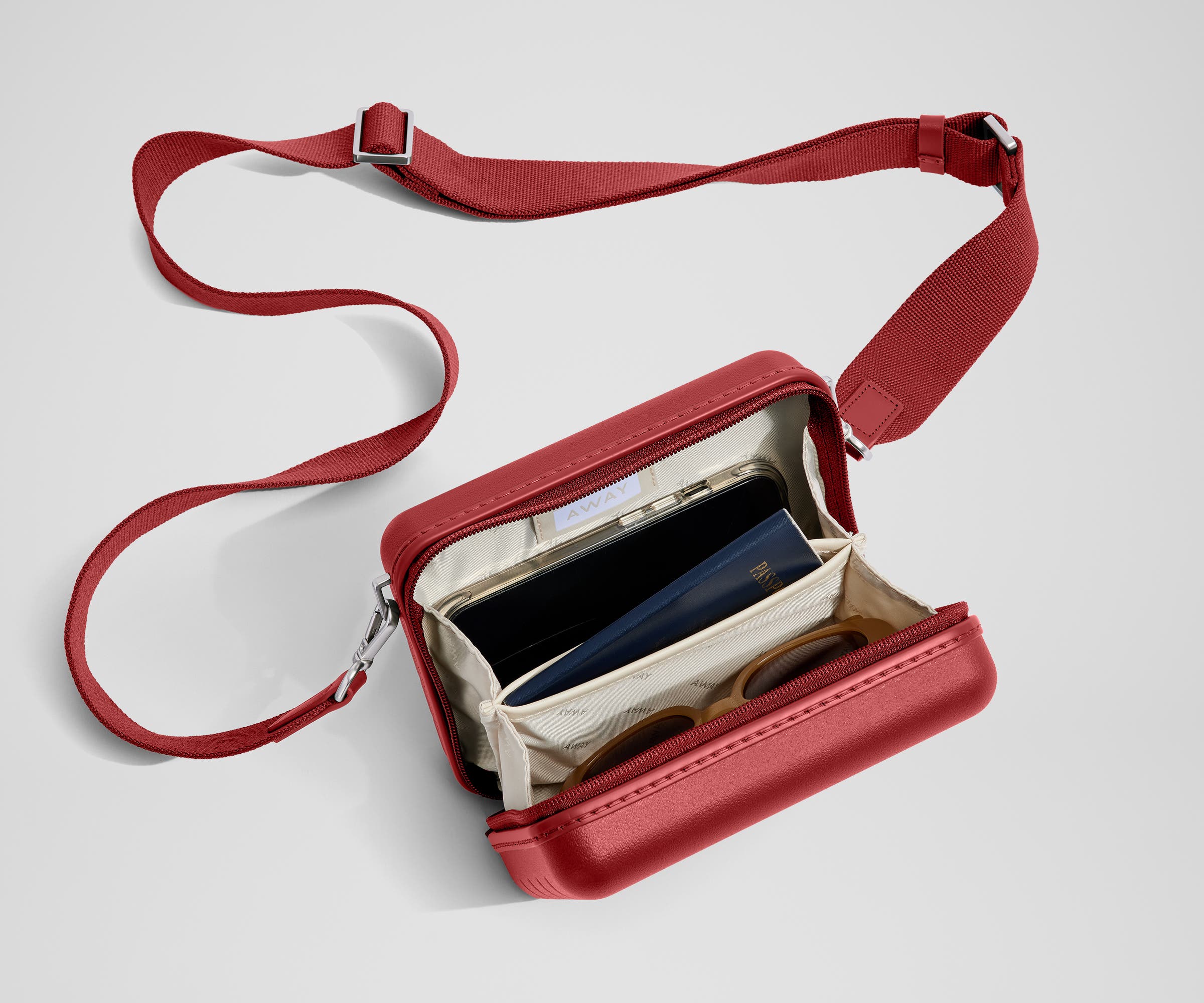 The Mini Crossbody packed with a phone, passport, and sunglasses