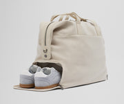 A pair of sneakers in the zippered shoe compartment