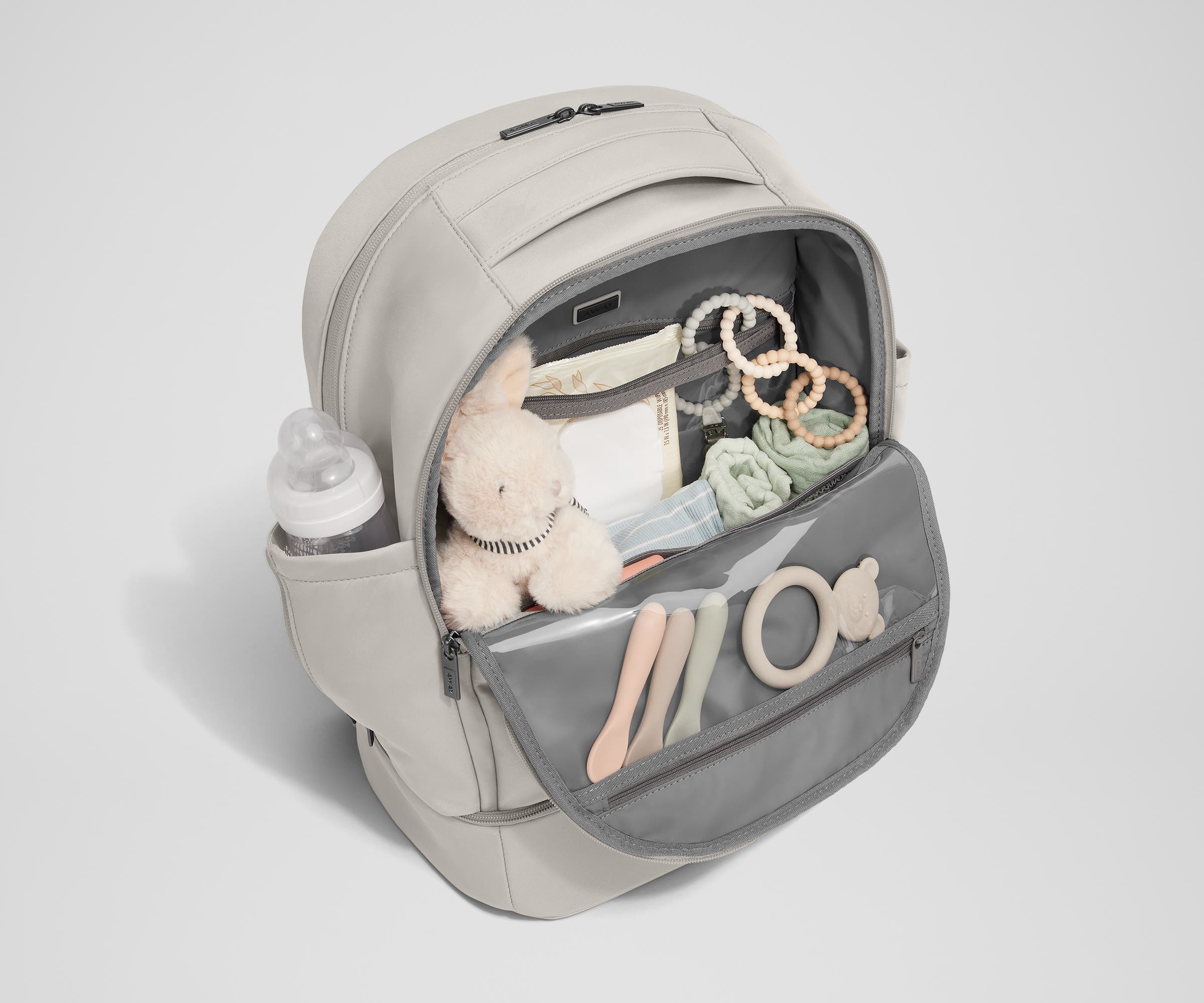Front main compartment packed with child essentials, including a stuffed animal, wipes, and change of clothes