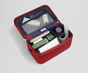 Train case packed with multiple grooming essentials, including a razor, nail care, and lotions