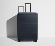 Front product view of The Large suitcase in Navy Blue with raised handle
