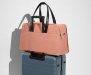 Weekender sitting on an Away Large suitcase, using the trolley sleeve pass-through