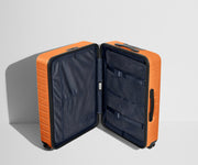 The Medium suitcase in Sorbet Orange shown open in an upright position to show interior organization and compression system