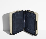 The Bigger Carry-On suitcase in Salt White (Gloss) shown open in an upright position to show interior organization and compression system
