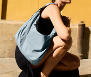 Person wearing the Large Featherlight Crossbody in Arctic Blue