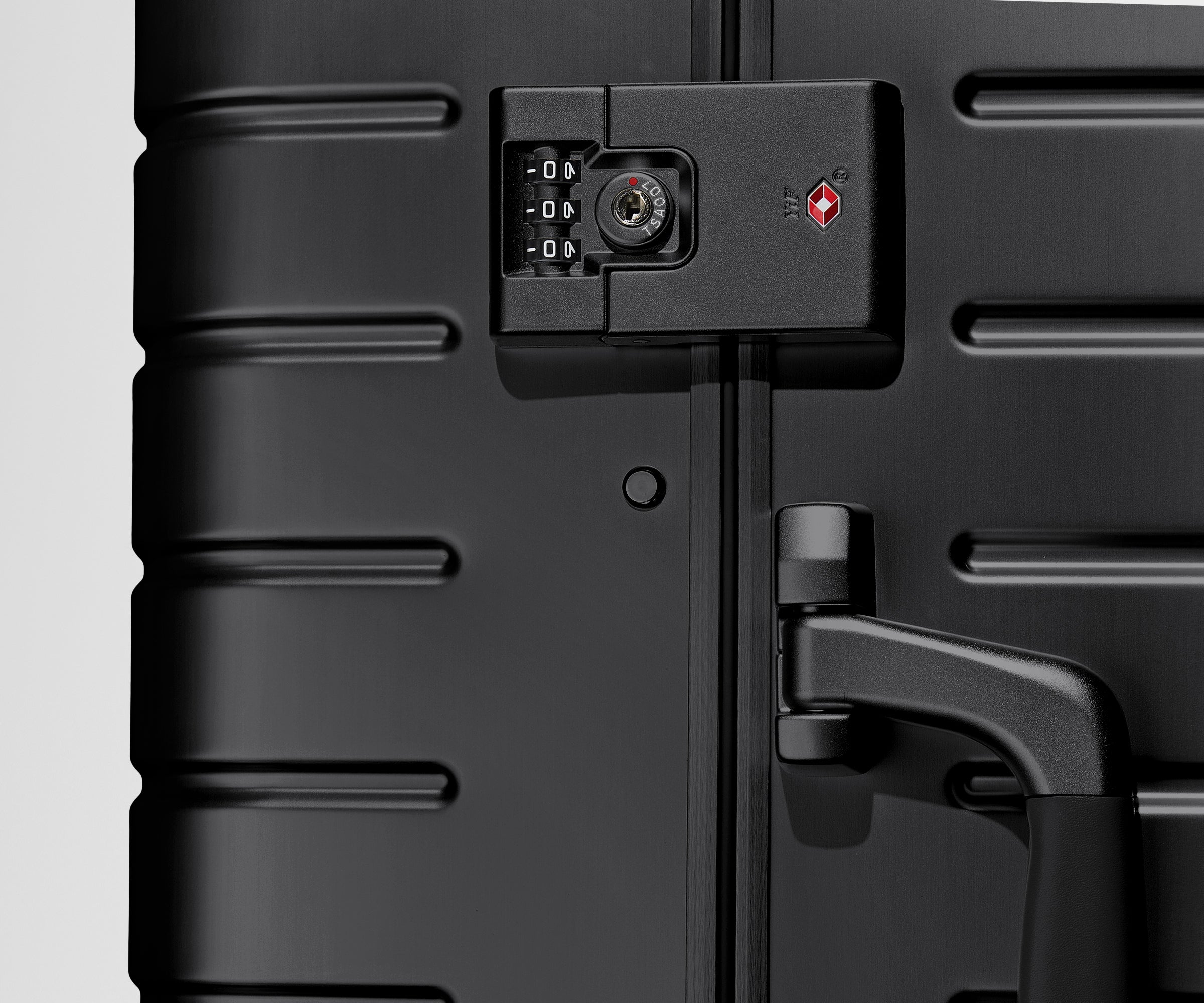 Close up view of the TSA ock on the side of an Aluminum suitcase in Onyx Black