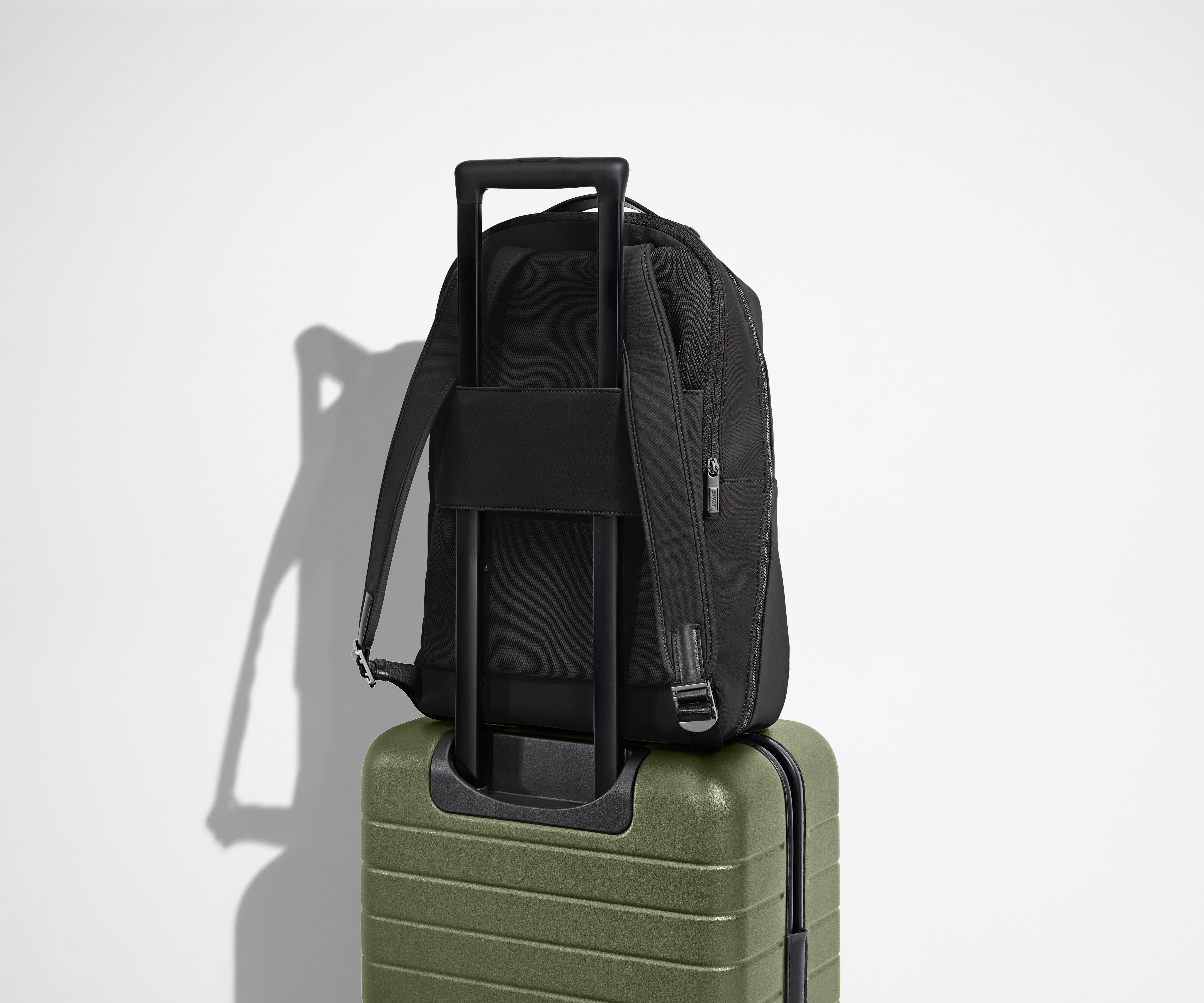 Back view of the Everywhere Zip Backpack on an Away suitcase