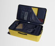 The Trunk suitcase in Sunshine Yellow shown open on its side and packed with Away's packing organizers to show capacity and the interior compression system, designed to help you pack more in