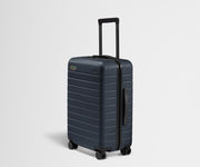 Dark blue suitcase with a handle and wheels on a light gray background