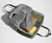 Green weekender duffle packed with a toiletry bag and clothing