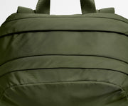 Close-up of a green backpack with straps on a white background