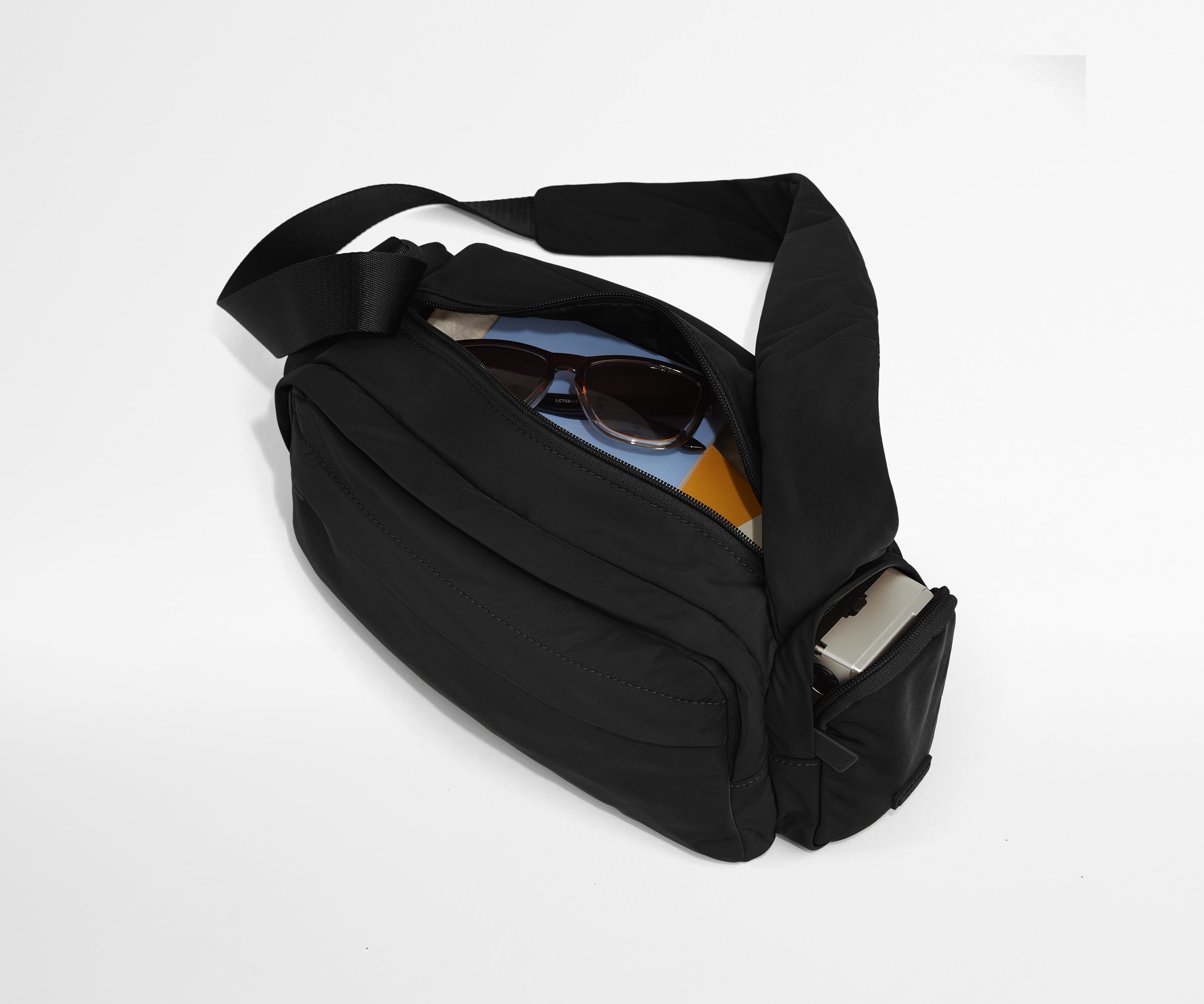 Featherlight Cargo Pack packed with notebooks, sunglasses, and a camera