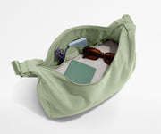 Featherlight crossbody packed with a sweater, notebook, sunglasses, and portable charger