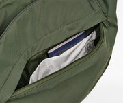 Green backpack with a pocket open, revealing a book and a card inside.