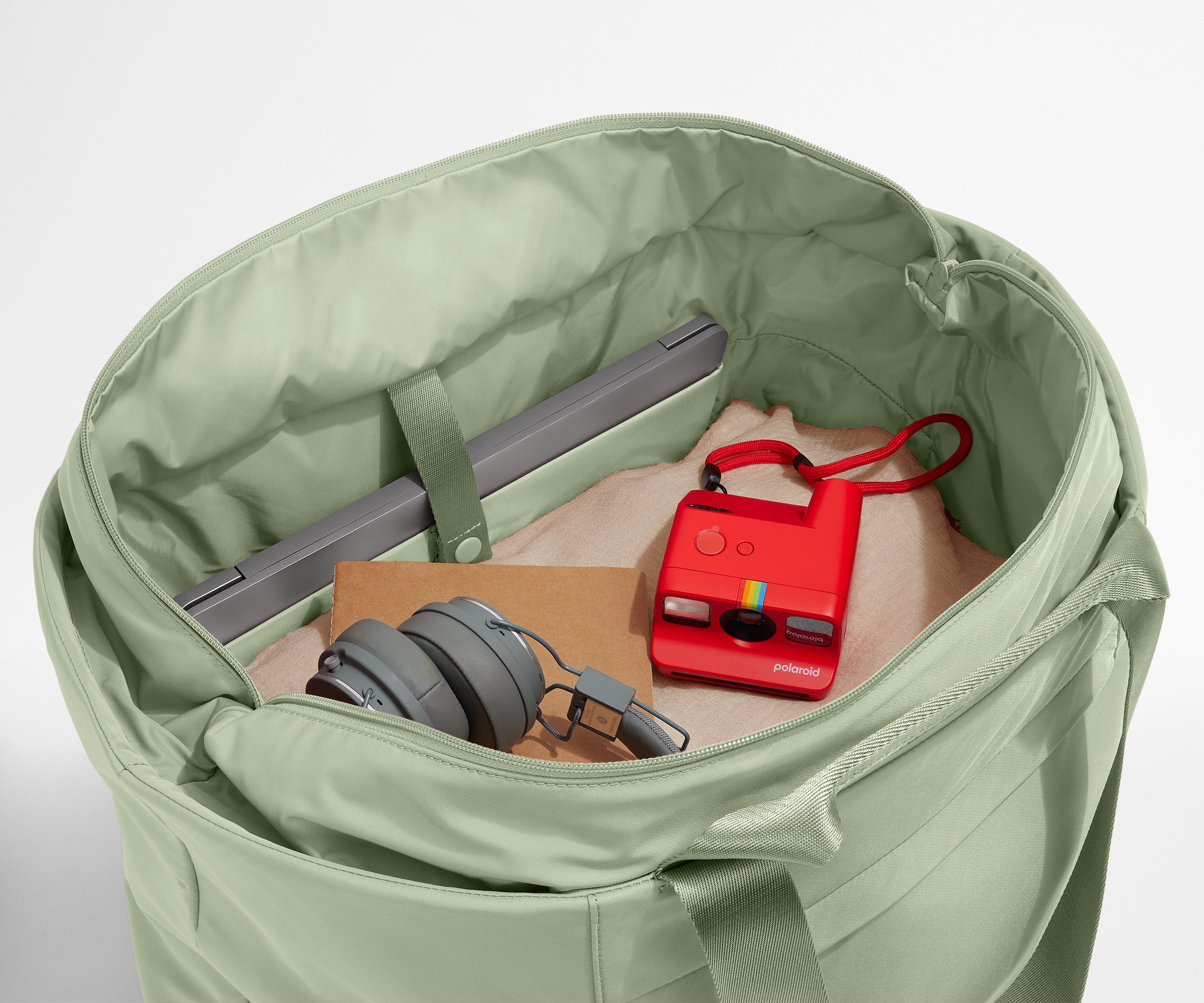 Interior packed with clothing, a laptop, headphones, notebook, and camera