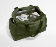 Green duffel bag with items inside on a white background
