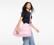 Person holding a pink bag against a white background