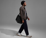 Person wearing the Featherlight Weekender as a crossbody with the detachable strap