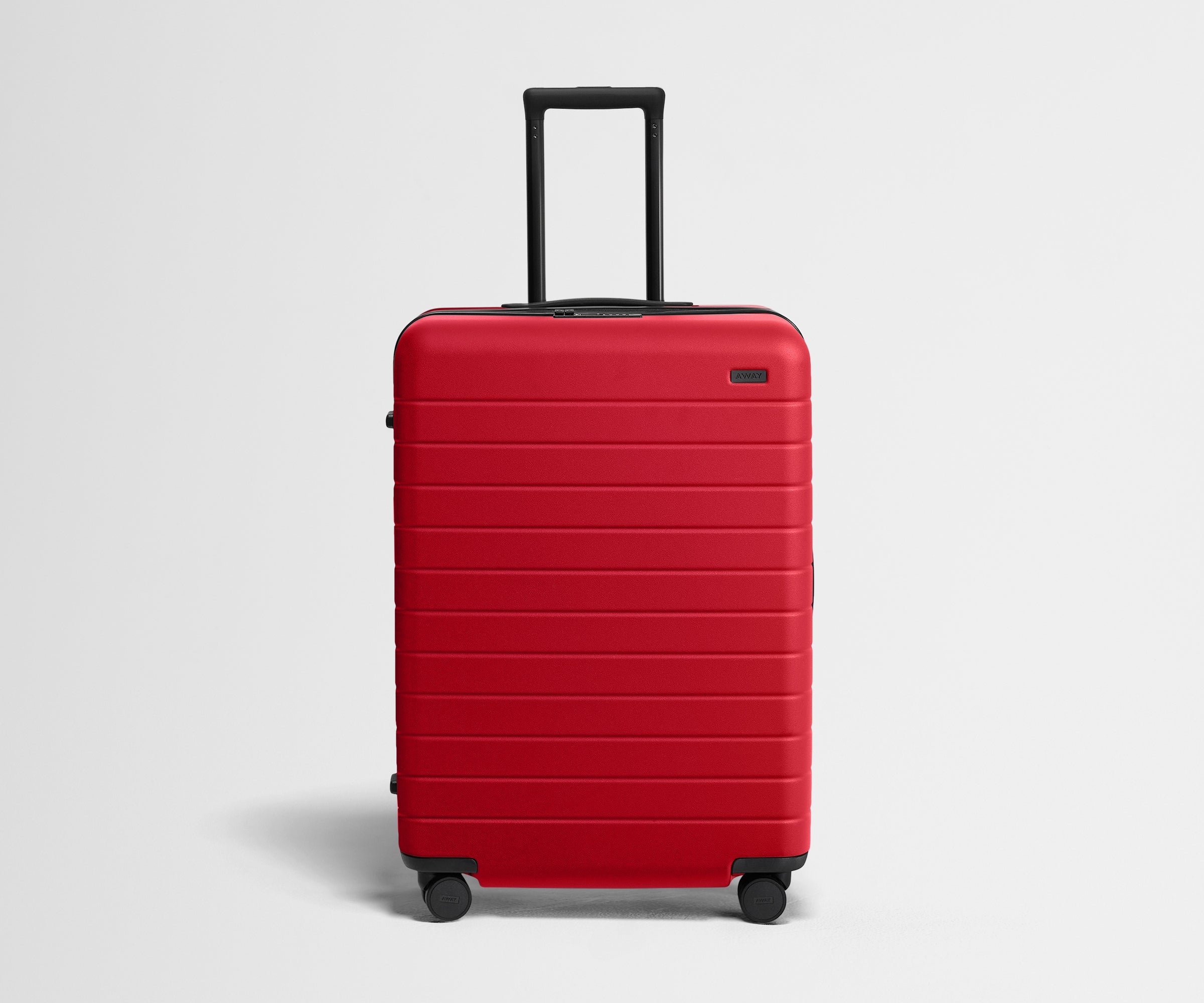 Red suitcase with a black handle on a light gray background