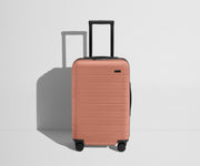 Front product view of The Carry-On Flex suitcase in Clay Pink with raised handle