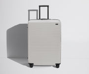 Front product view of The Large Flex suitcase in Cloud Gray with raised handle