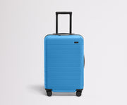 Front product view of The Bigger Carry-On Flex suitcase in Splash Blue with raised handle