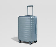 Blue suitcase on a light gray background