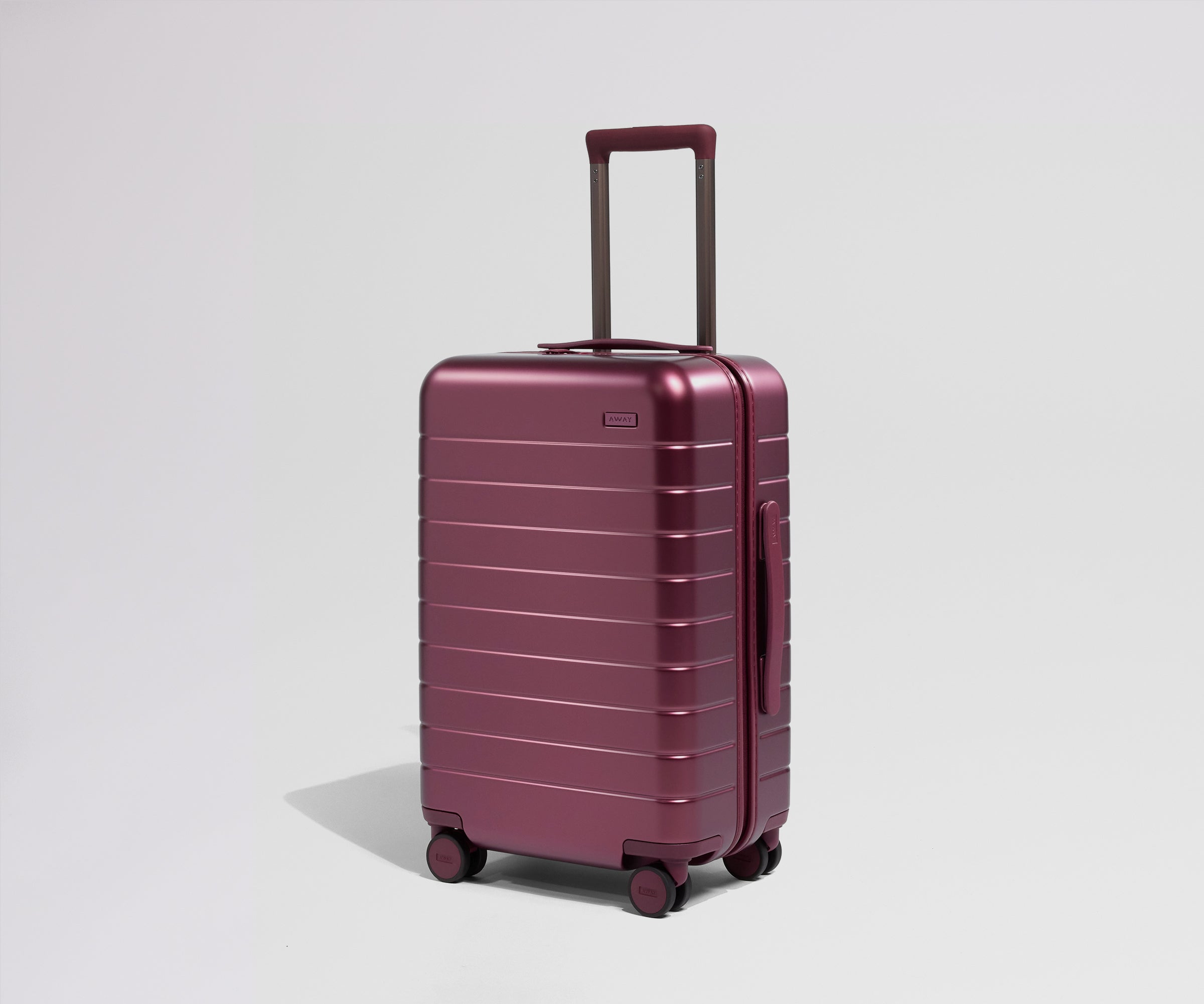 Maroon suitcase with a handle on a light gray background