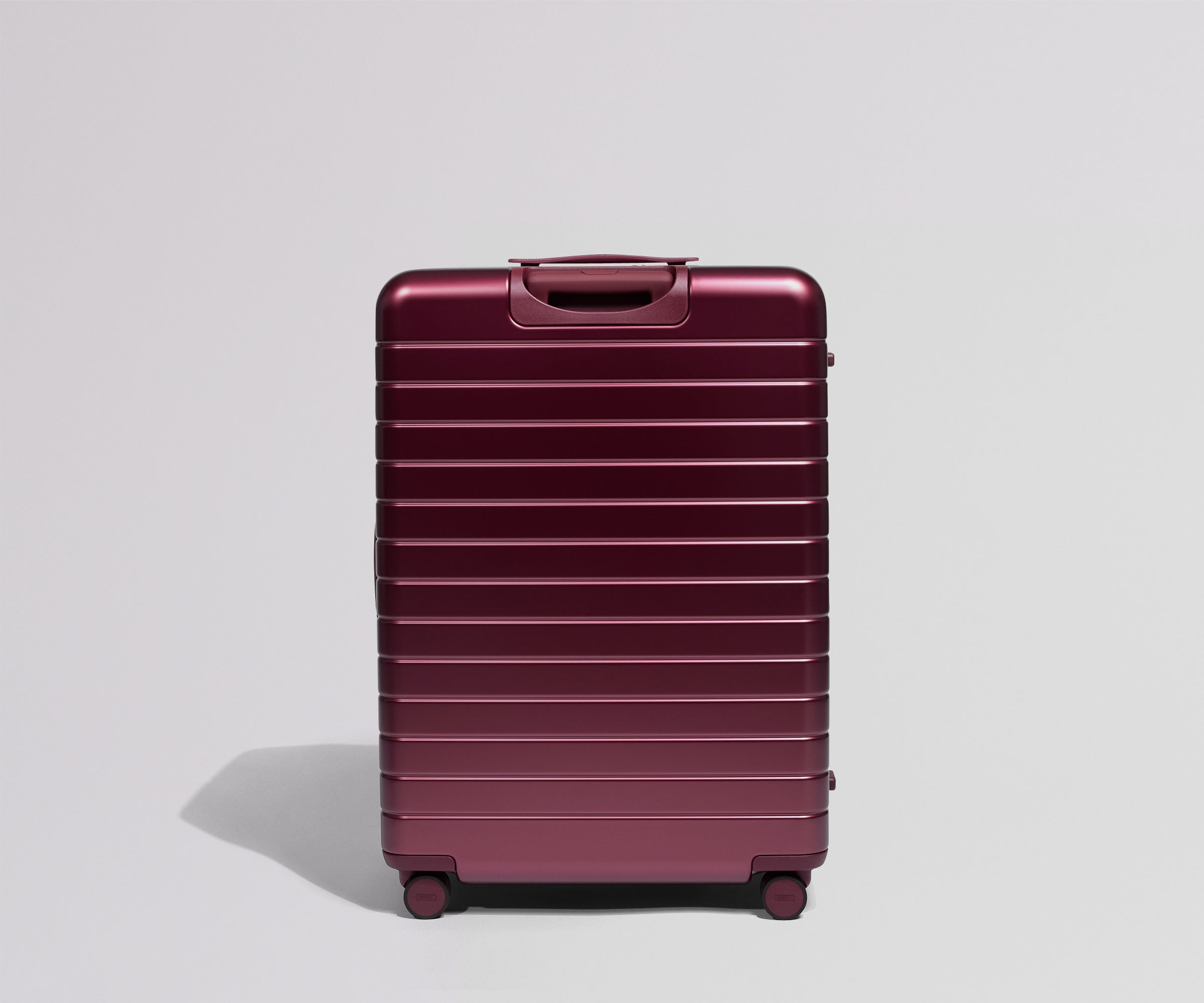 Maroon suitcase on a light gray background