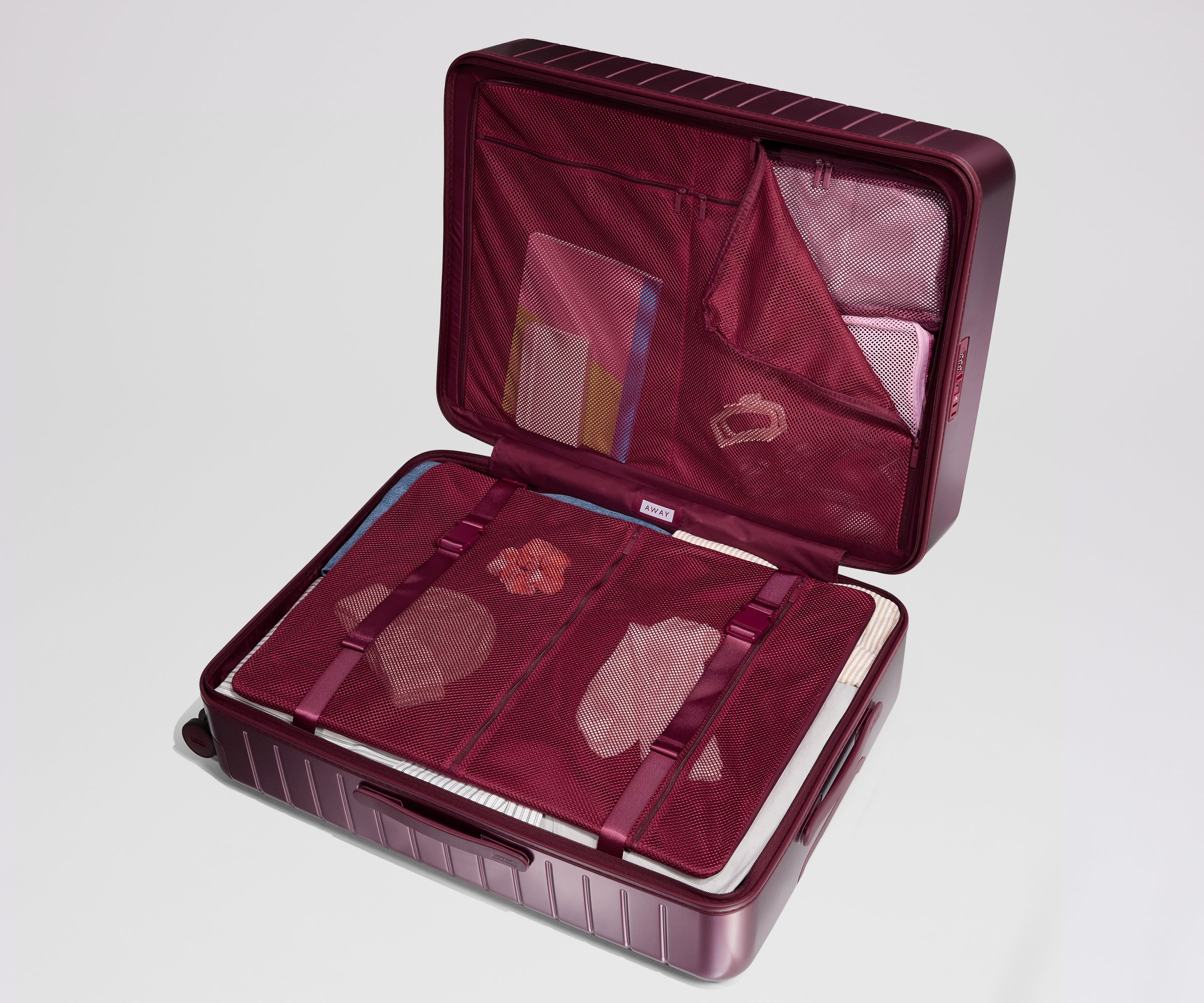 Open maroon suitcase with interior compartments on a light gray background